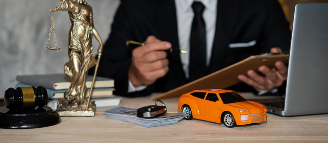 Small cars, keys and scales. Goddess of justice with hammer, money and laptop, and businessman holding a pen to sign a contract under car title approval concept.